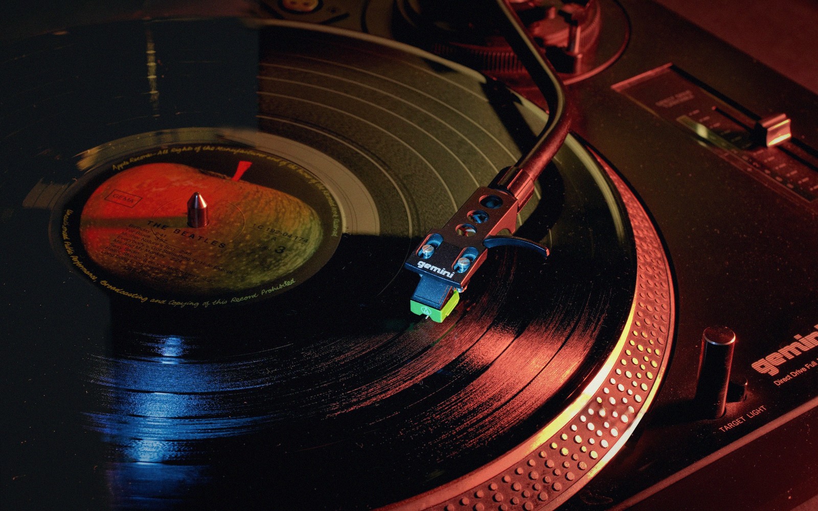 A tonearm rests on a spinning vinyl record on a turntable